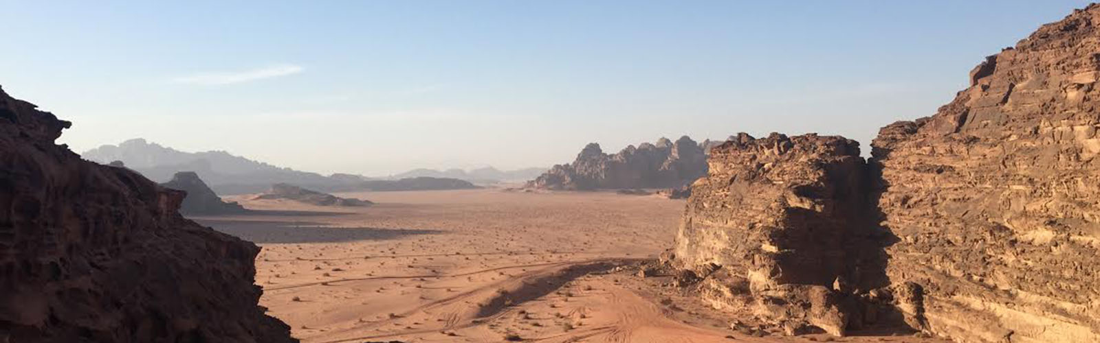 A vast desert with tall, rocky mountains on the left and right. 